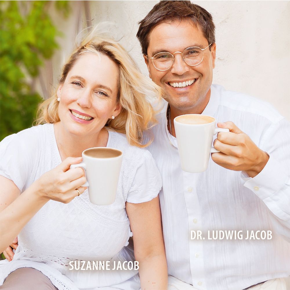 Zwei Personen halten Tassen. Dr. Ludwig Jacob und Suzanne Jacob. Beide lächeln.