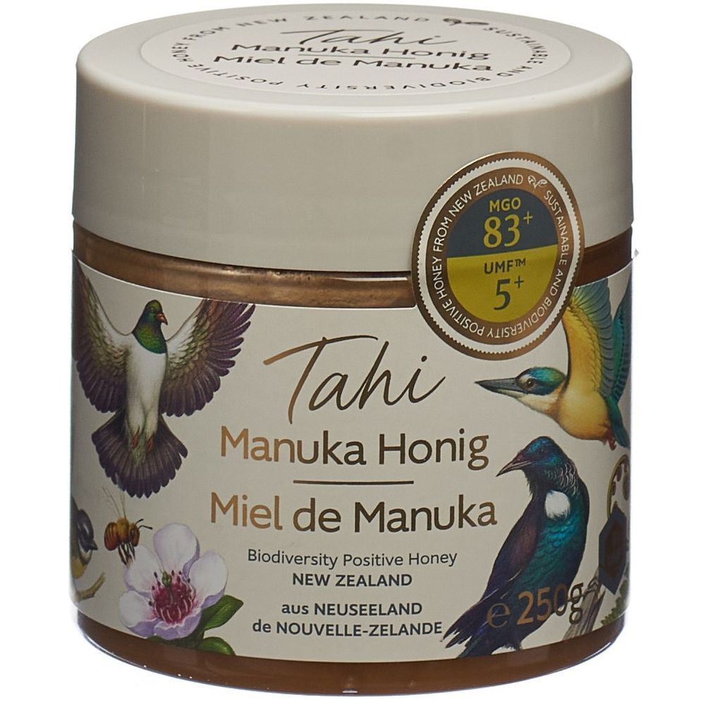 Glas mit Honig. Aufschrift: Tahi Manuka Honig, Miel de Manuka. UMF 5+, MGO 83+. Mit Illustrationen von Vögeln und Blumen.