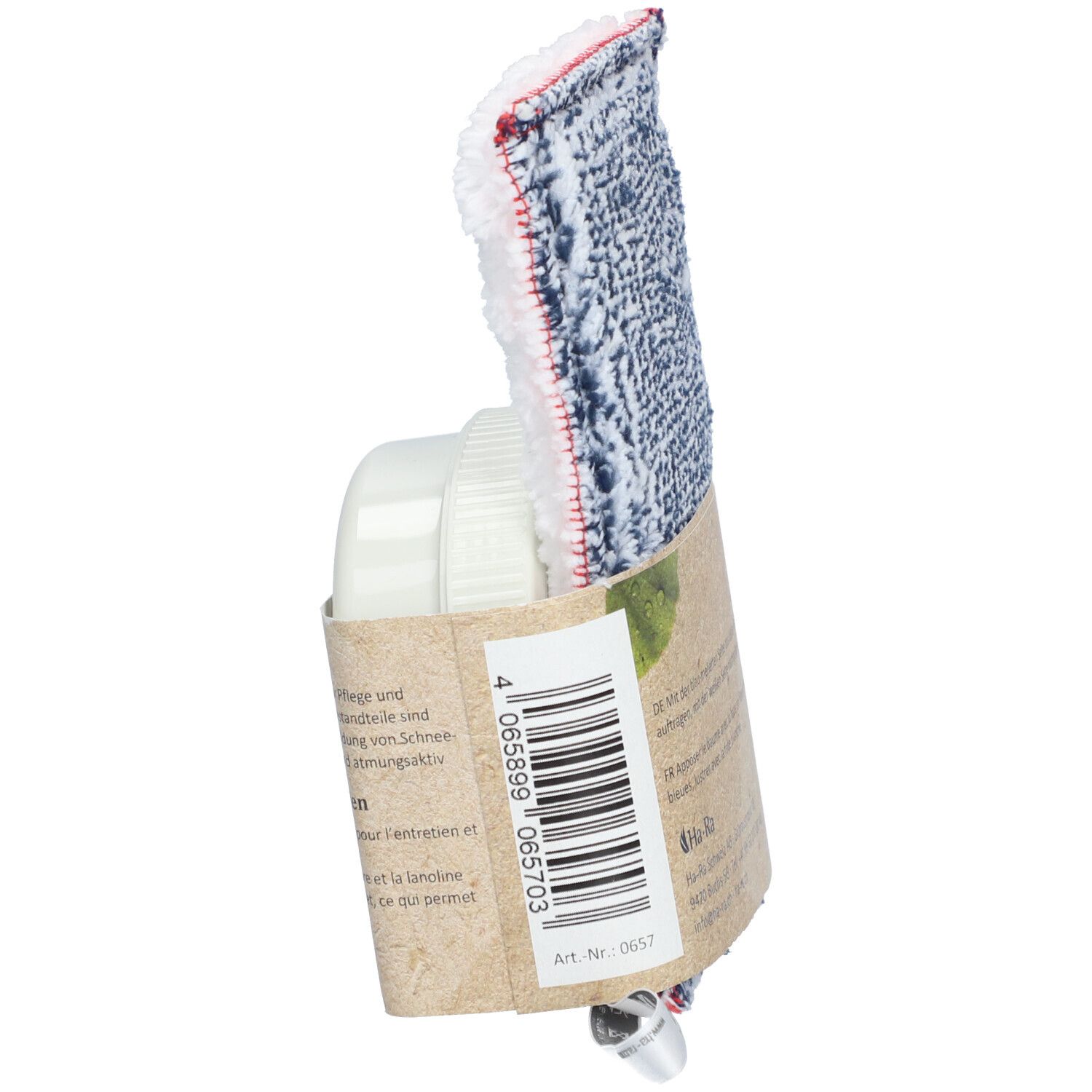 Seitenansicht der Verpackung mit Pflegetuch und Behälter. Tuch mit blau-weißem Muster und rotem Rand. Behälter und Verpackung aus Papier.