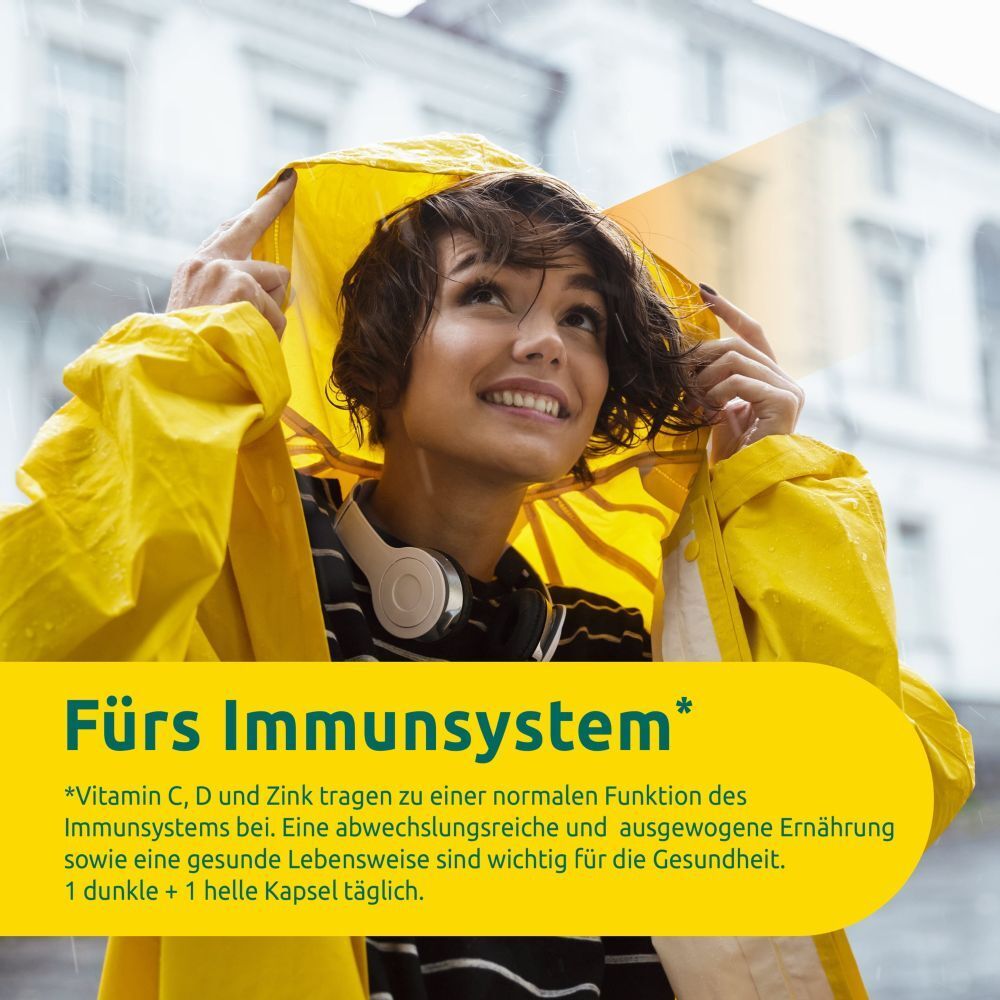 Person im gelben Regenmantel. Text: "Fürs Immunsystem". Erwähnung von Vitaminen C, D, Zink. Empfehlung: 1 dunkle + 1 helle Kapsel täglich.