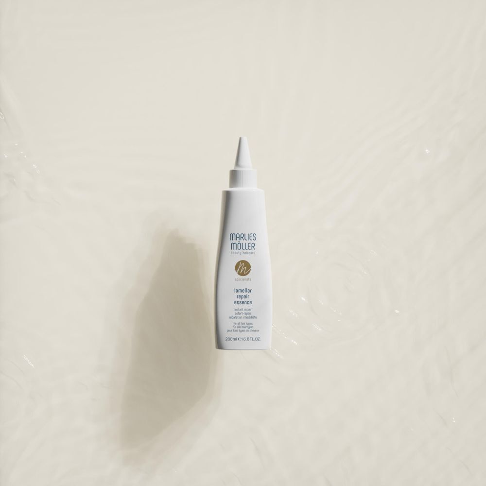 Weiße Flasche mit Spitze, Marlies Möller, Lamellar Repair Essence, auf hellem Hintergrund. Produktansicht von oben.