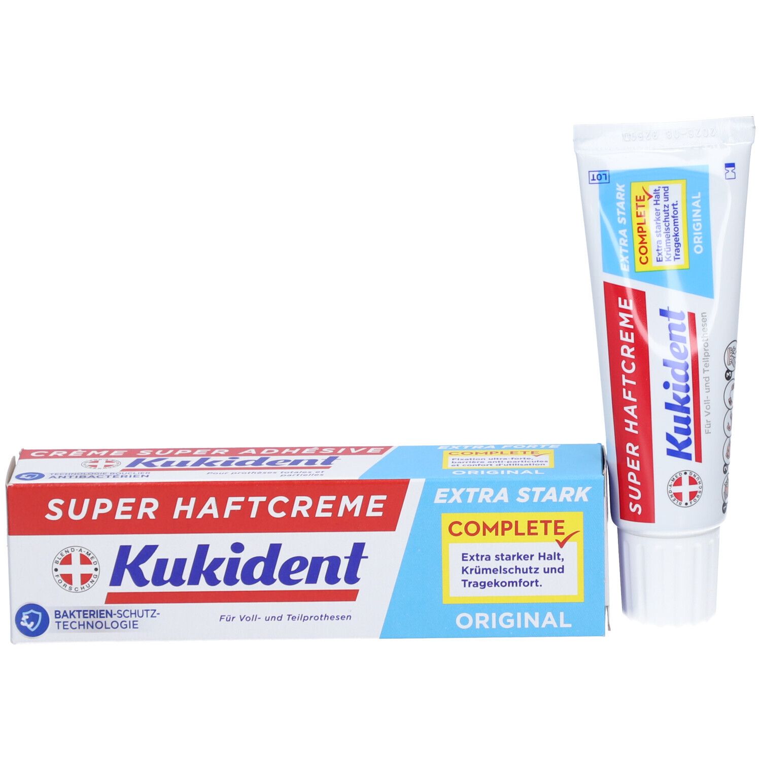 Crème adhésive pour prothèses dentaires et emballage. Marque : Kukident. Texte : Super Haftcreme, Extra Stark, Original. Tube et boîte blancs avec texte bleu et rouge.