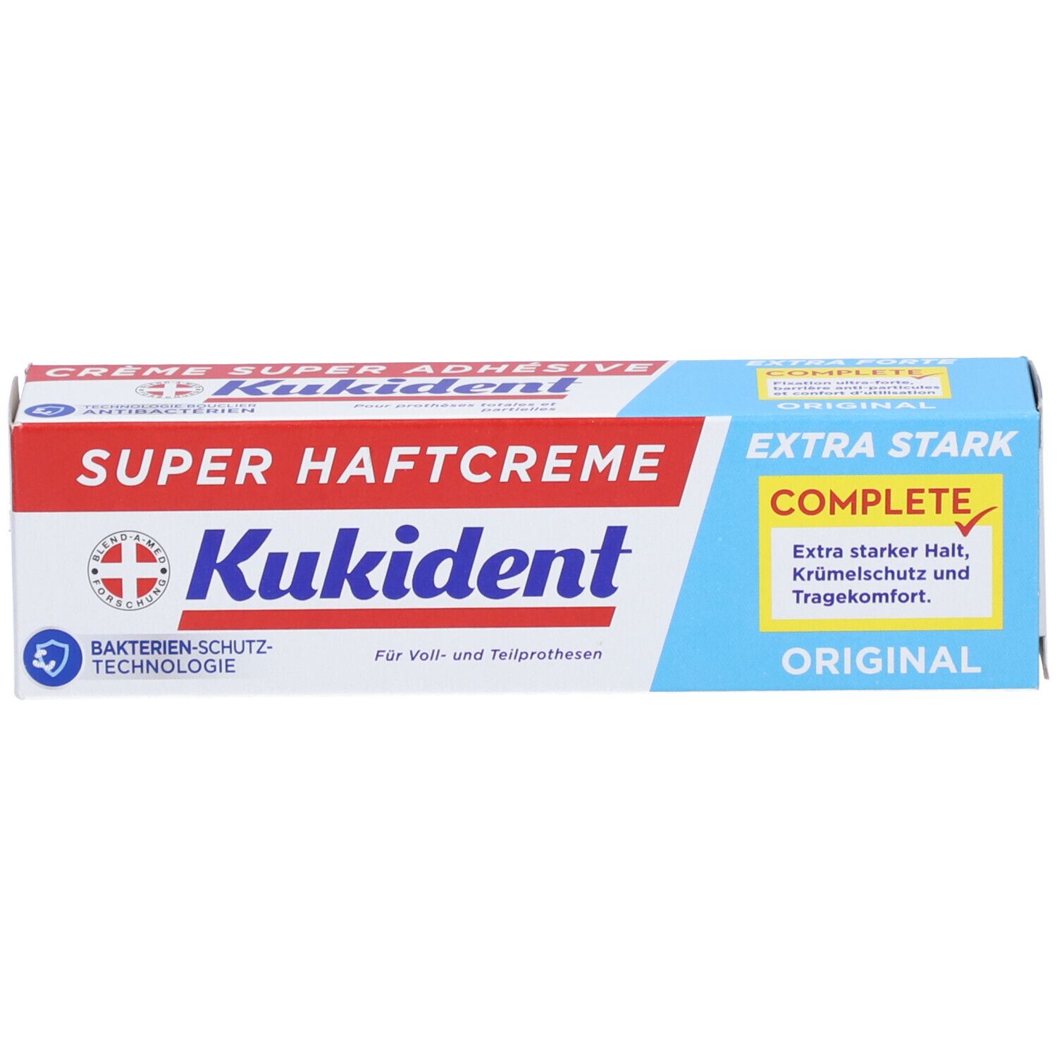 Emballage de la crème adhésive pour prothèses dentaires. Marque : Kukident. Texte : Super Haftcreme, Extra Stark, Original. Boîte bleue et rouge.