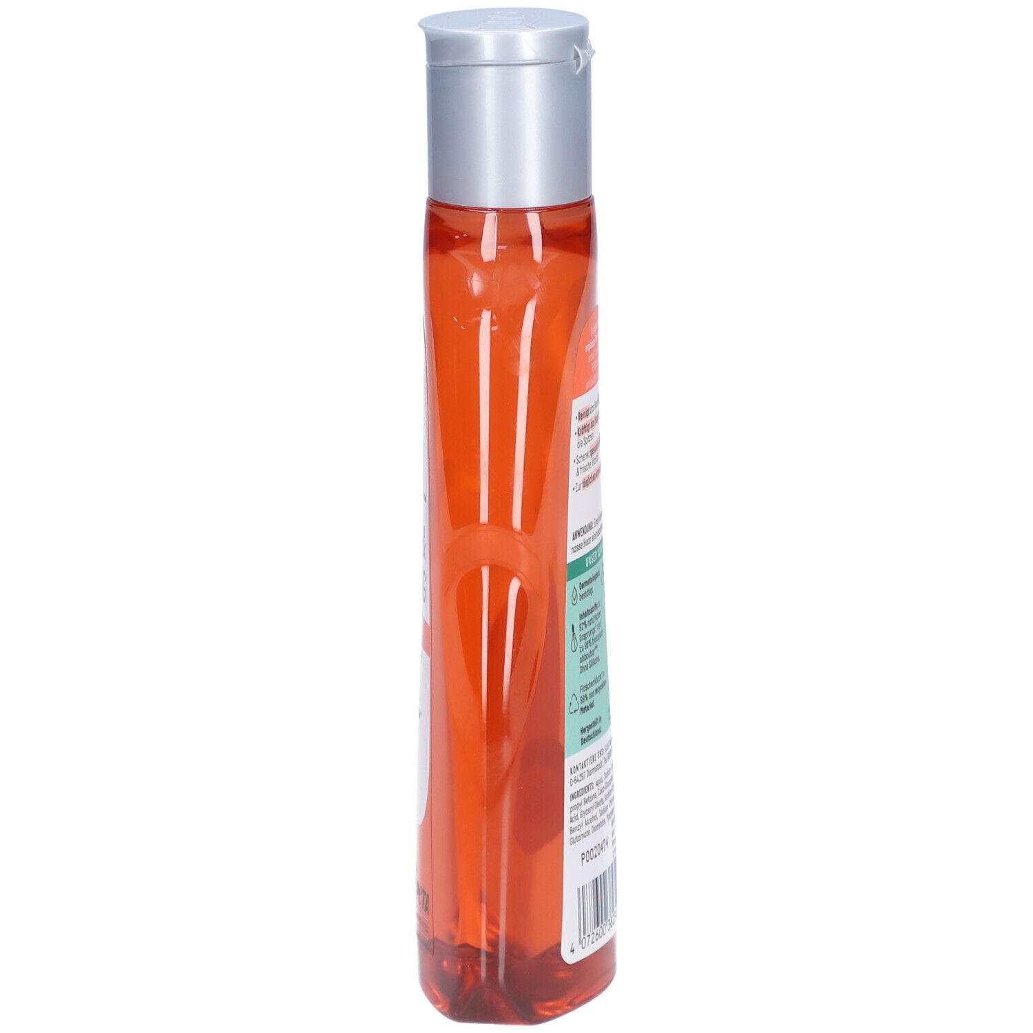 Schmale, transparente Flasche mit orangefarbenem Shampoo. Silberner Deckel. Aufschrift auf der Seite.
