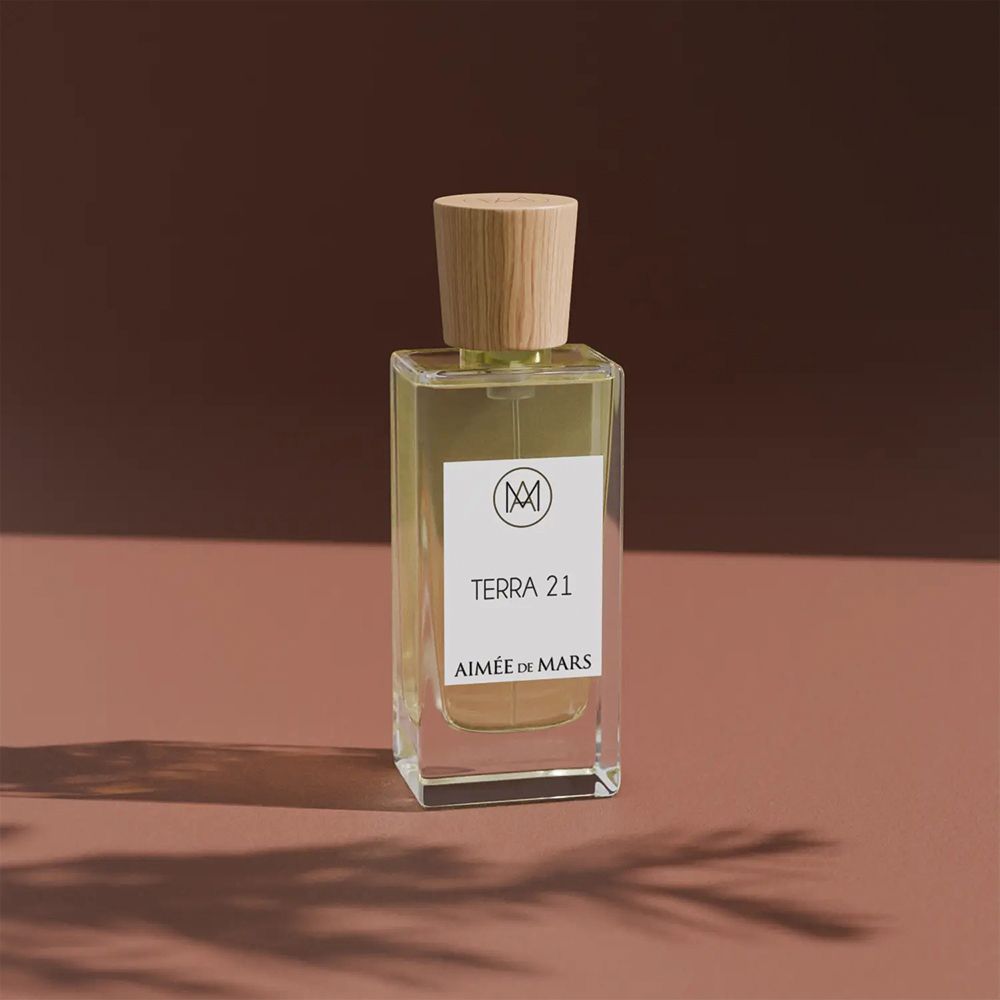 Glasflasche mit Holzverschluss. Aufkleber mit Text: Terra 21, Aimée de Mars. Rosa Hintergrund.
