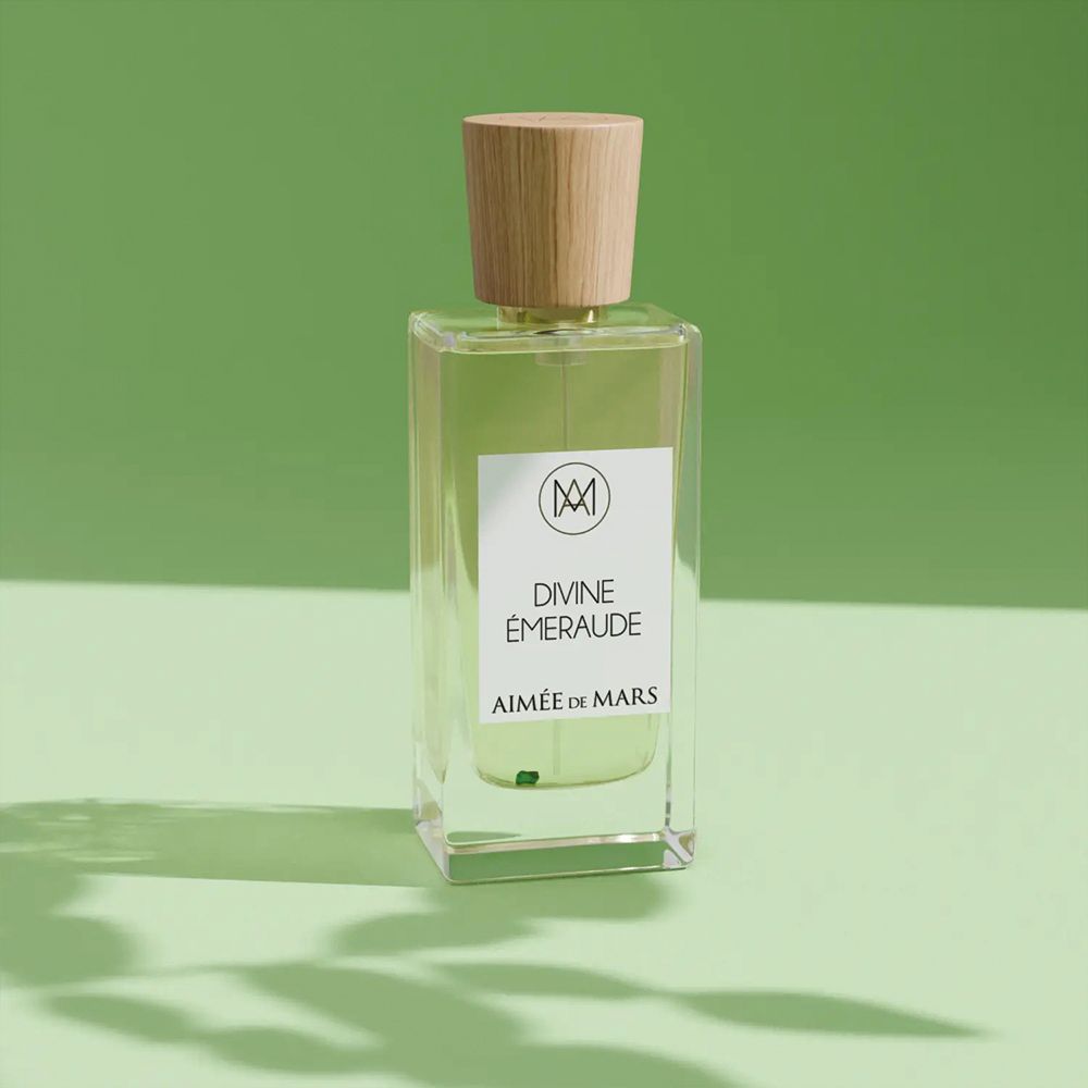 Flakon mit Holzverschluss. Aufschrift: Divine Émeraude, Aimée de Mars. Grüner Hintergrund.