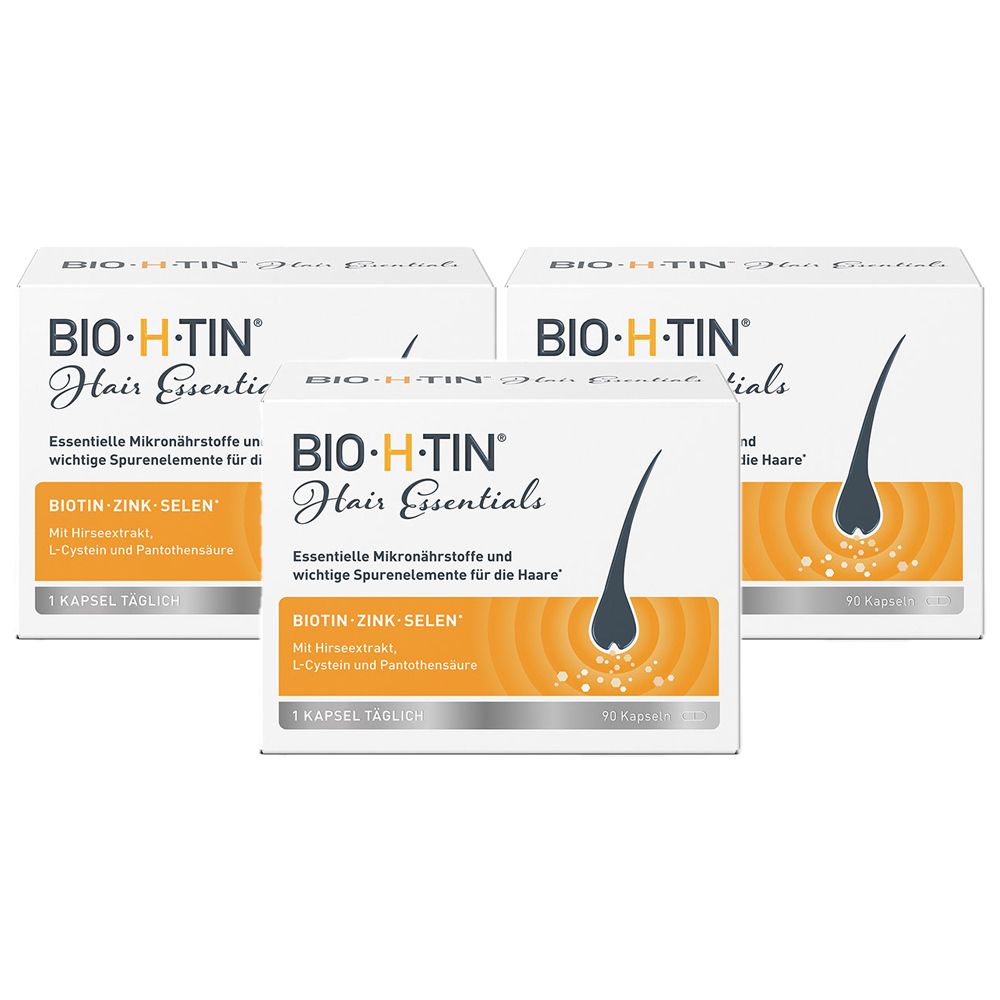 Drei Schachteln BIO-H-TIN Hair Essentials. Weiße Verpackung mit Produktnamen und Haarillustration. Enthält Biotin, Zink, Selen.