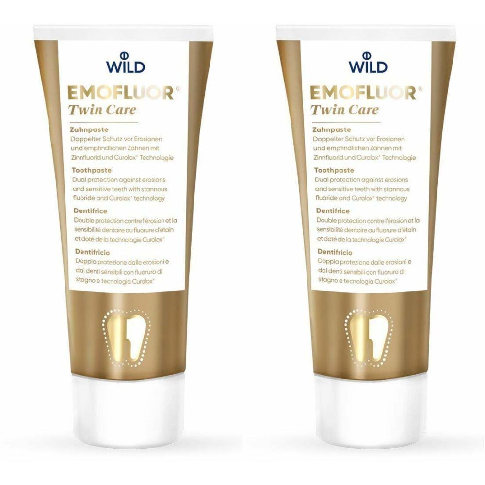 Zwei Tuben Zahnpasta, goldfarben-weiß. Aufschrift: EMOFLUOR Twin Care, Zahncreme. Logo: Wild.