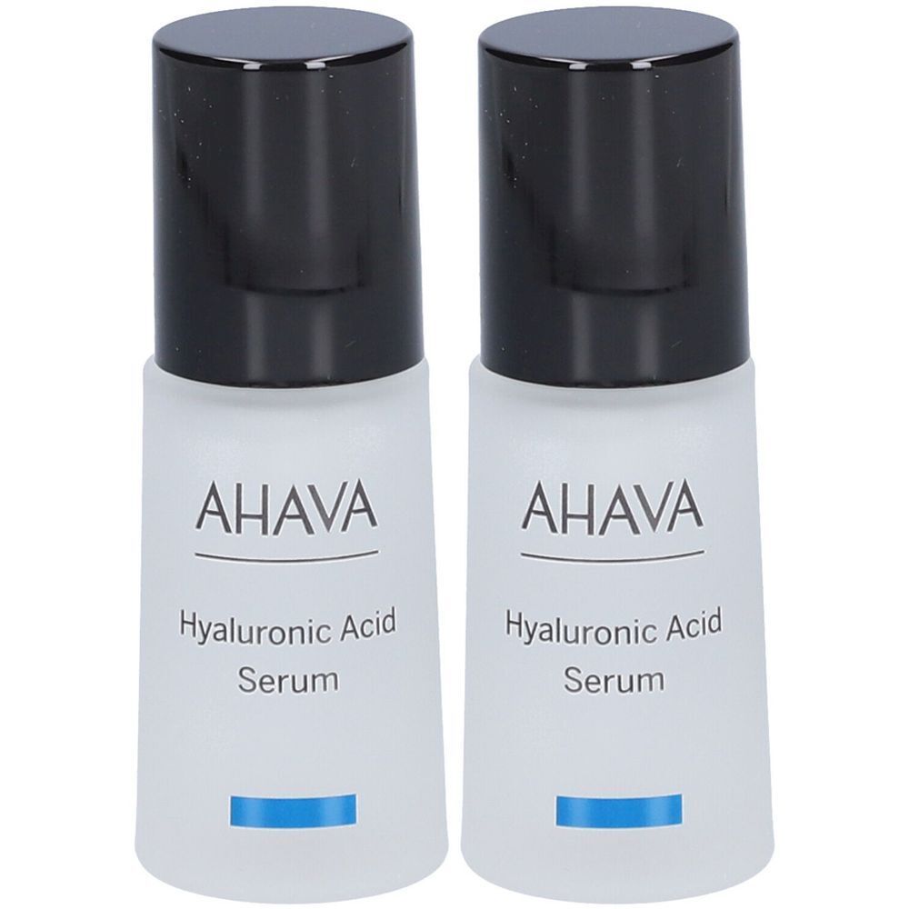 Twee flacons met zwarte dop. Opschrift AHAVA, Hyaluronic Acid Serum. Blauwe lijn onderaan.
