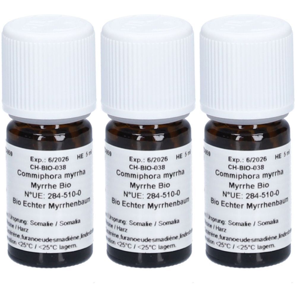 Drei kleine braune Glasflaschen mit weißen Deckeln. Auf den Etiketten stehen Informationen wie "Commiphora myrrha" und "Bio Echter Myrrhenbaum".