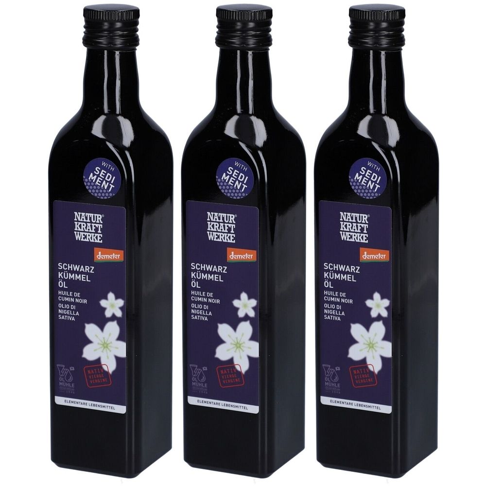 Trois bouteilles noires avec des étiquettes. Les étiquettes indiquent "NATUR KRAFT WERKE" et "SCHWARZ KÜMMEL OL".
