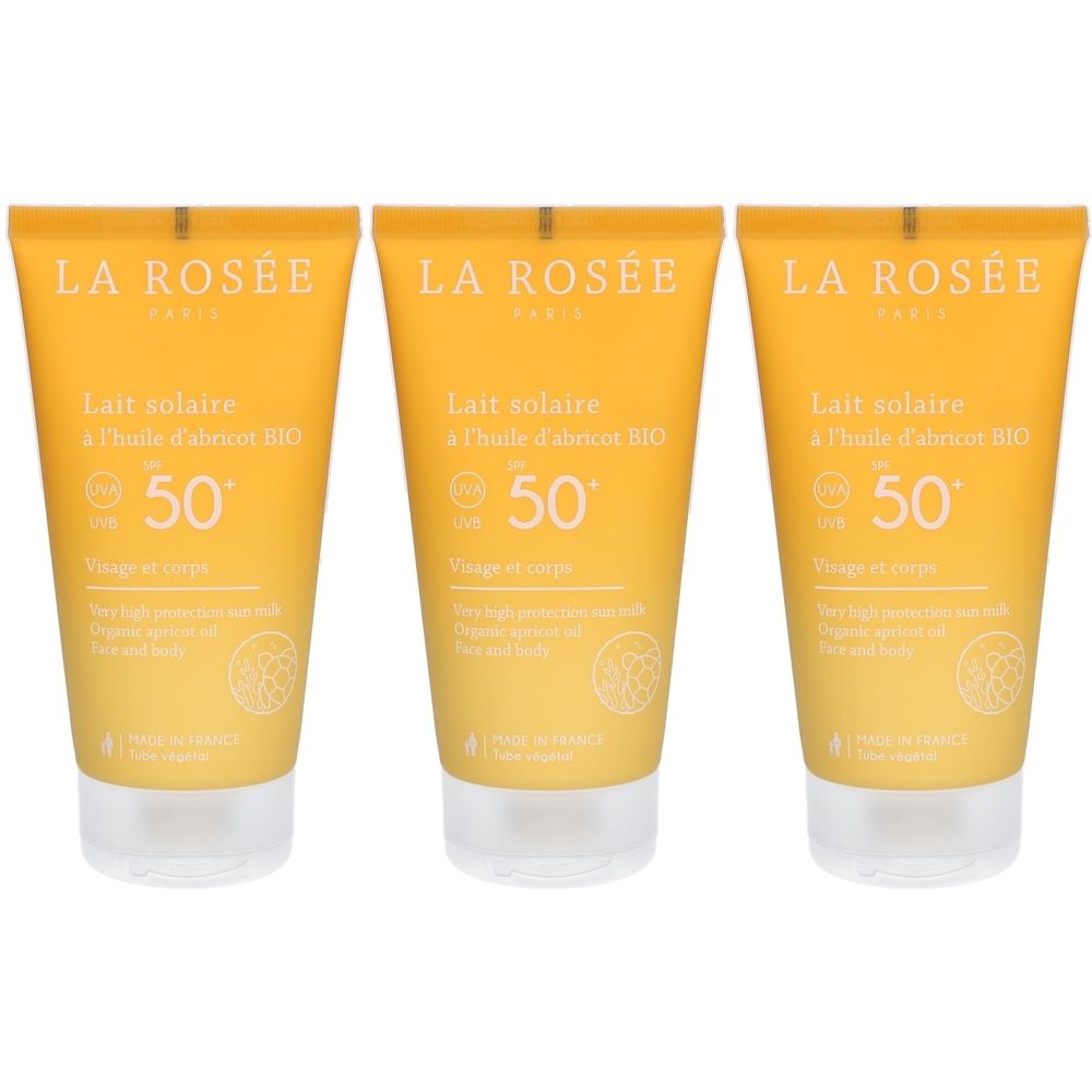 Trois tubes de lait solaire LA ROSÉE SPF 50+ à l'huile d'abricot BIO. Emballage jaune orangé. Texte visible.