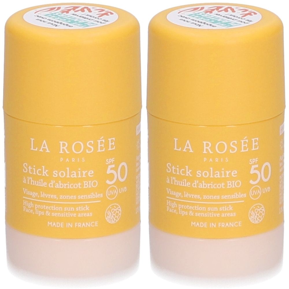 Zwei gelbe Sonnenschutzstifte mit weißem Boden. Aufschrift: LA ROSÉE, Stick solaire SPF 50, à l'huile d'abricot BIO. Made in France.