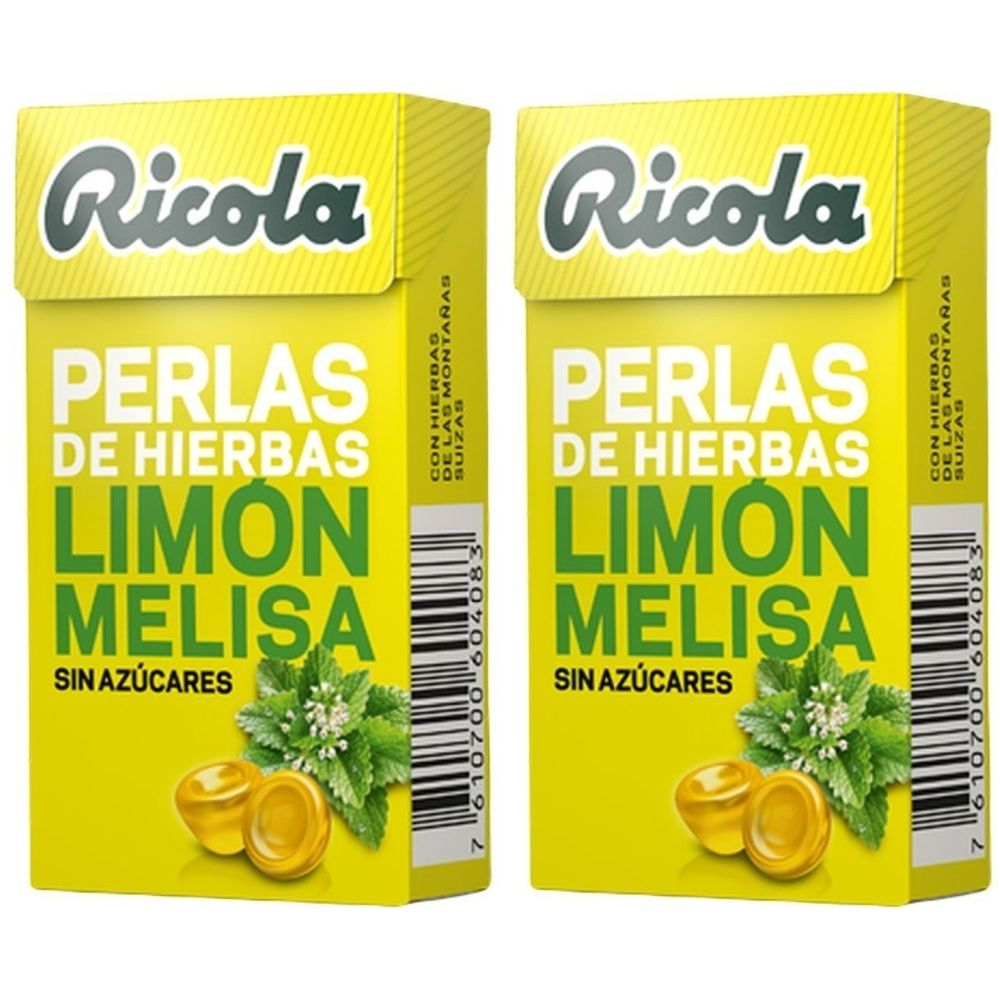 Zwei gelbe Schachteln mit "Ricola"-Logo. Aufschrift: "PERLAS DE HIERBAS LIMON MELISA SIN AZÚCARES". Abbildung von Kräutern und Bonbons.
