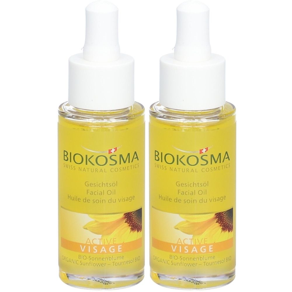 Deux flacons d'huile pour le visage BIOKOSMA Active Visage. Liquide jaune dans des flacons en verre avec des bouchons blancs. Inscription : BIOKOSMA, Gesichtsol, Active Visage.