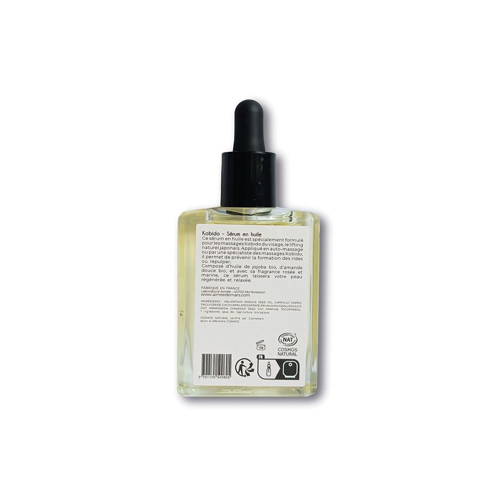 Rückansicht einer quadratischen Glasflasche mit Ölserum. Etikett mit Text und Barcode. Schwarzer Tropfer.