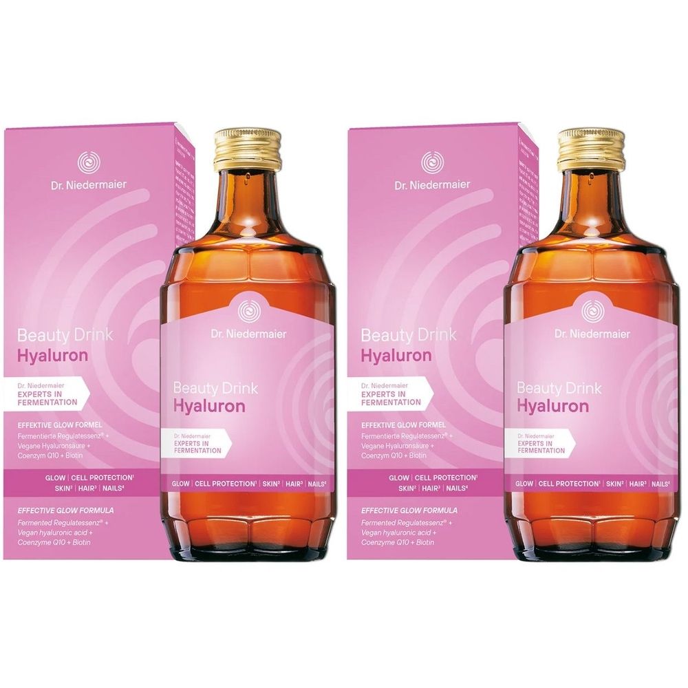 Deux bouteilles et deux emballages de Beauty Drink Hyaluron. Bouteilles en verre brun avec bouchon doré. Emballage rose.