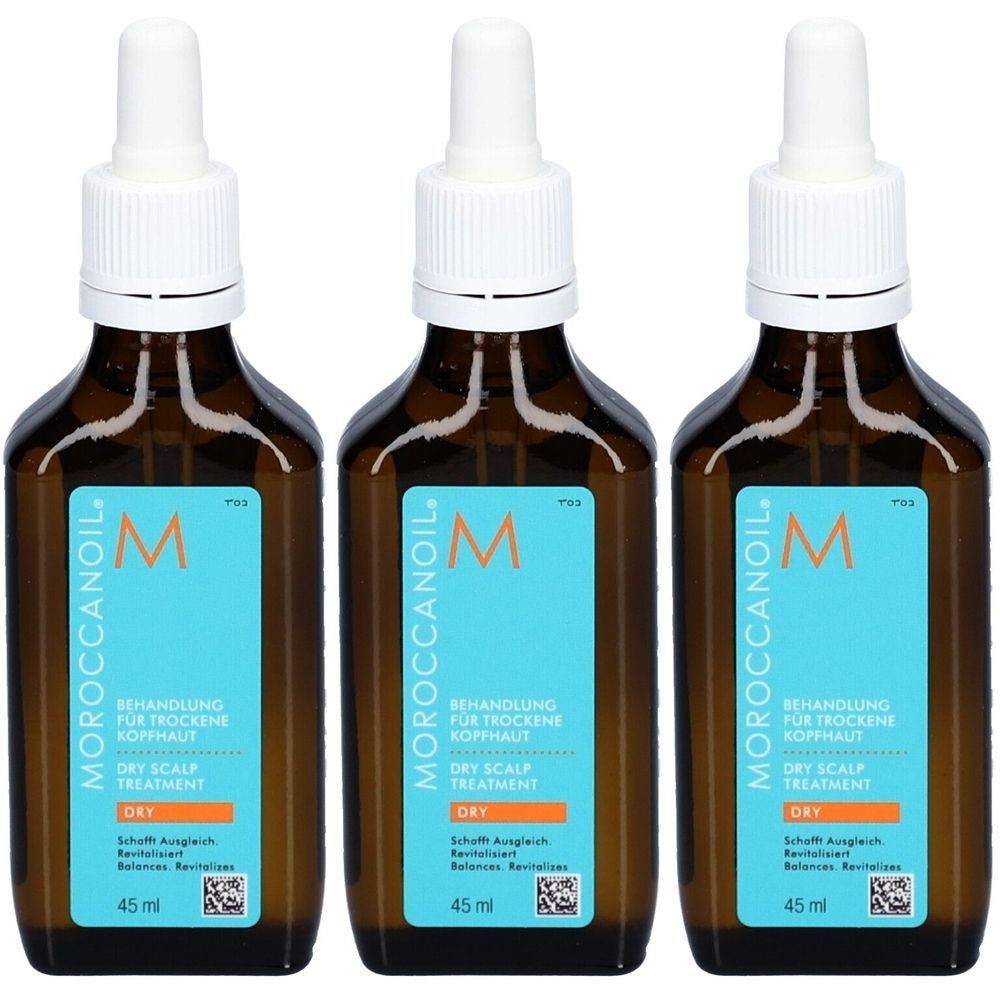 Drei Flaschen Moroccanoil-Behandlung für trockene Kopfhaut. Braune Glasflaschen mit weißem Deckel und blauen Etiketten mit Text.