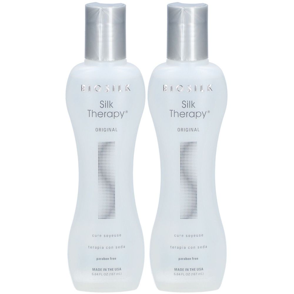 Zwei Flaschen BioSilk Silk Therapy. Weiße Flaschen mit silbernen Deckeln. Aufschrift: Silk Therapy, Original, parabenfrei.