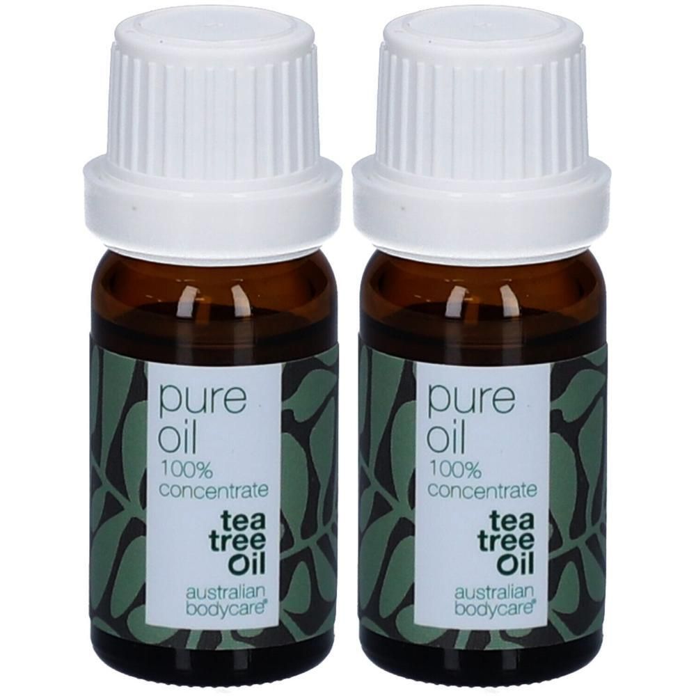 Twee flessen tea tree olie. Bruine glazen flessen met witte doppen en etiketten. Opschrift: pure oil, 100% concentrate, tea tree oil, Australian Bodycare.