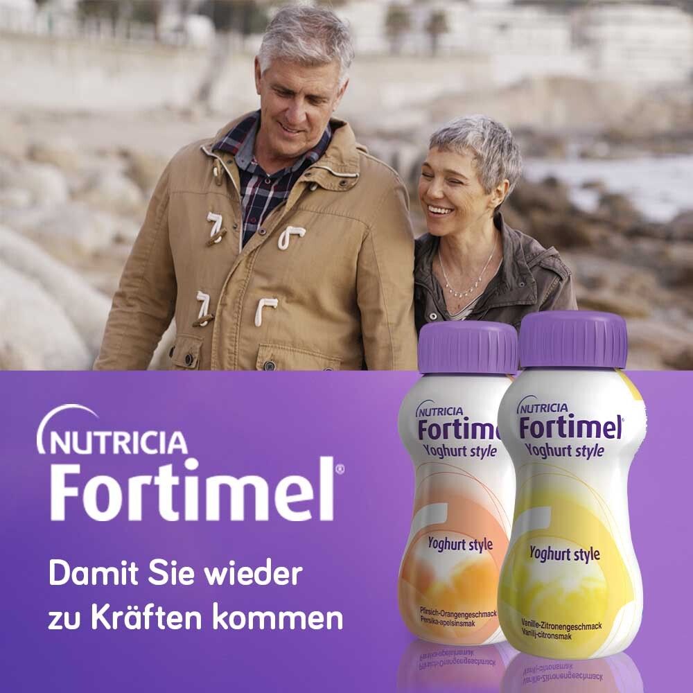 Zwei Flaschen Fortimel Yoghurt Style. Aufschrift: Himbeere. Im Hintergrund ein älteres Ehepaar am Strand.