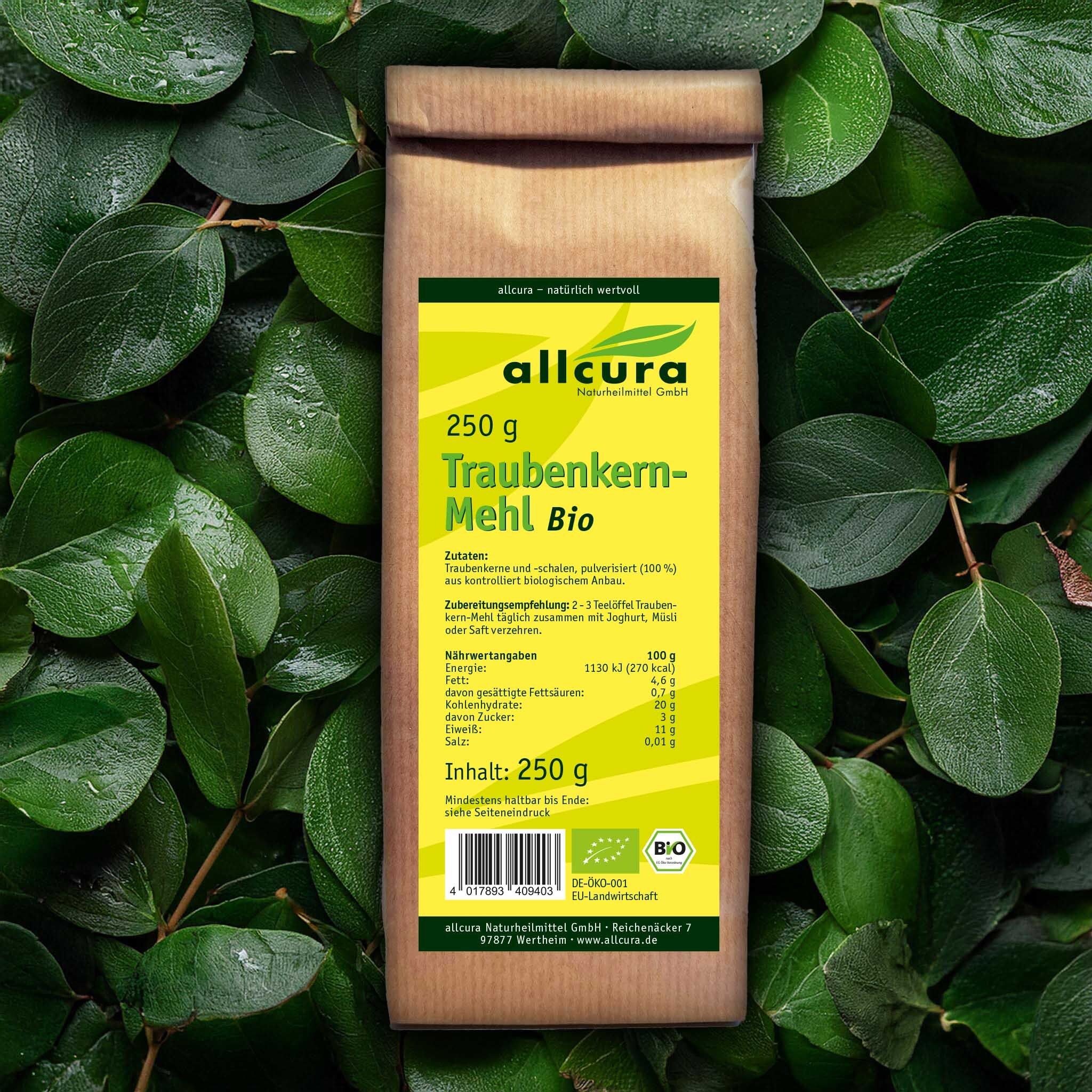 Braune Papiertüte mit gelbem Etikett, umgeben von grünen Blättern. Aufschrift: Traubenkern-Mehl Bio, 250 g. Bio-Siegel.