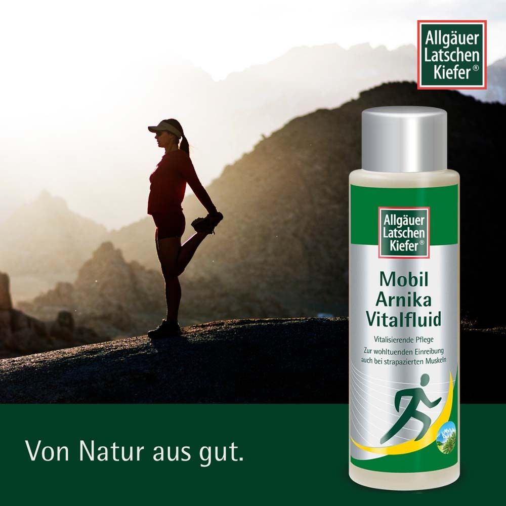 Frau dehnt sich auf einem Berg. Im Hintergrund Berge. Flasche mit Produktetikett: Allgäuer Latschenkiefer Mobil Arnika Vital Fluid.