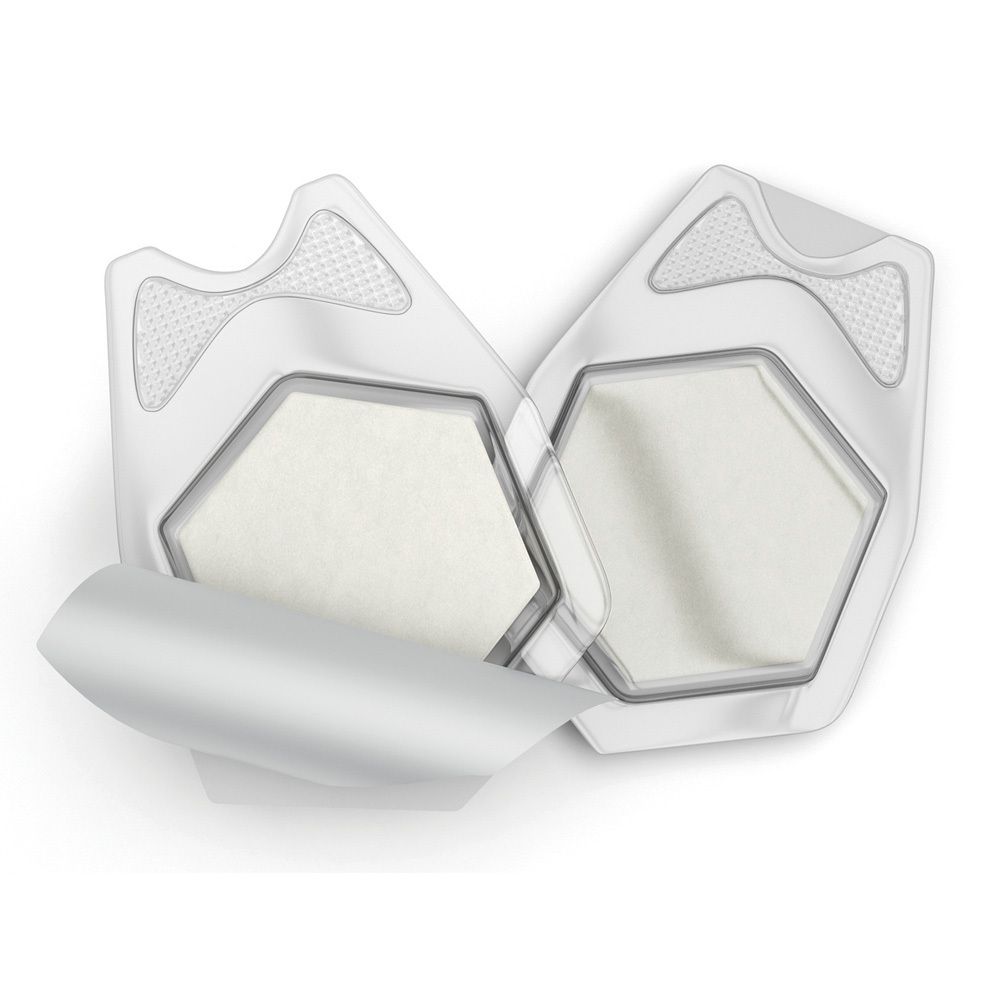 Zwei sterile Wundauflagen in geöffneter Verpackung. Sechseckige Form, weißes Material, transparente Hülle.