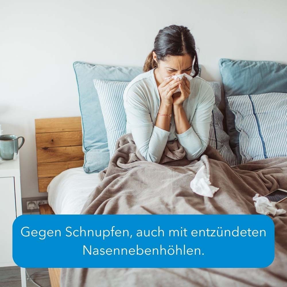 Frau im Bett mit Taschentuch. Text: Gegen Schnupfen, auch mit entzündeten Nasennebenhöhlen.