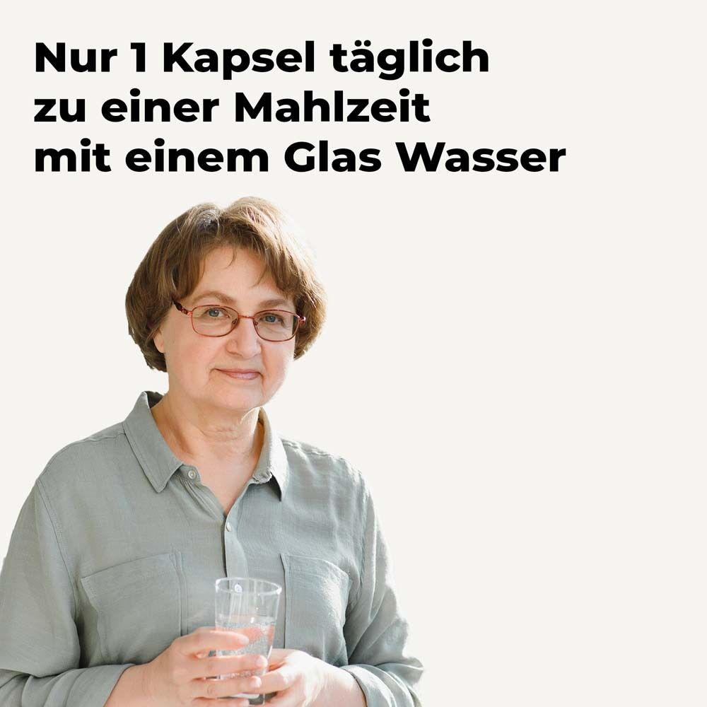 Frau mit Glas Wasser. Text: Nur 1 Kapsel täglich zu einer Mahlzeit mit einem Glas Wasser.
