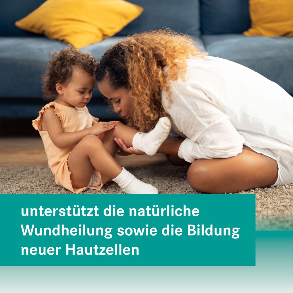 Mutter und Kind betrachten Knie. Text: unterstützt die natürliche Wundheilung sowie die Bildung neuer Hautzellen.