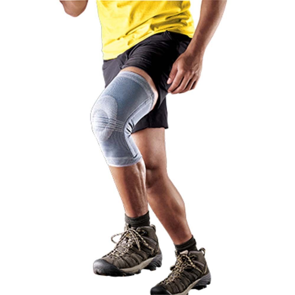 Person trägt eine graue Kniebandage. Bein mit Bandage und Schuhwerk. Hintergrund weiß.