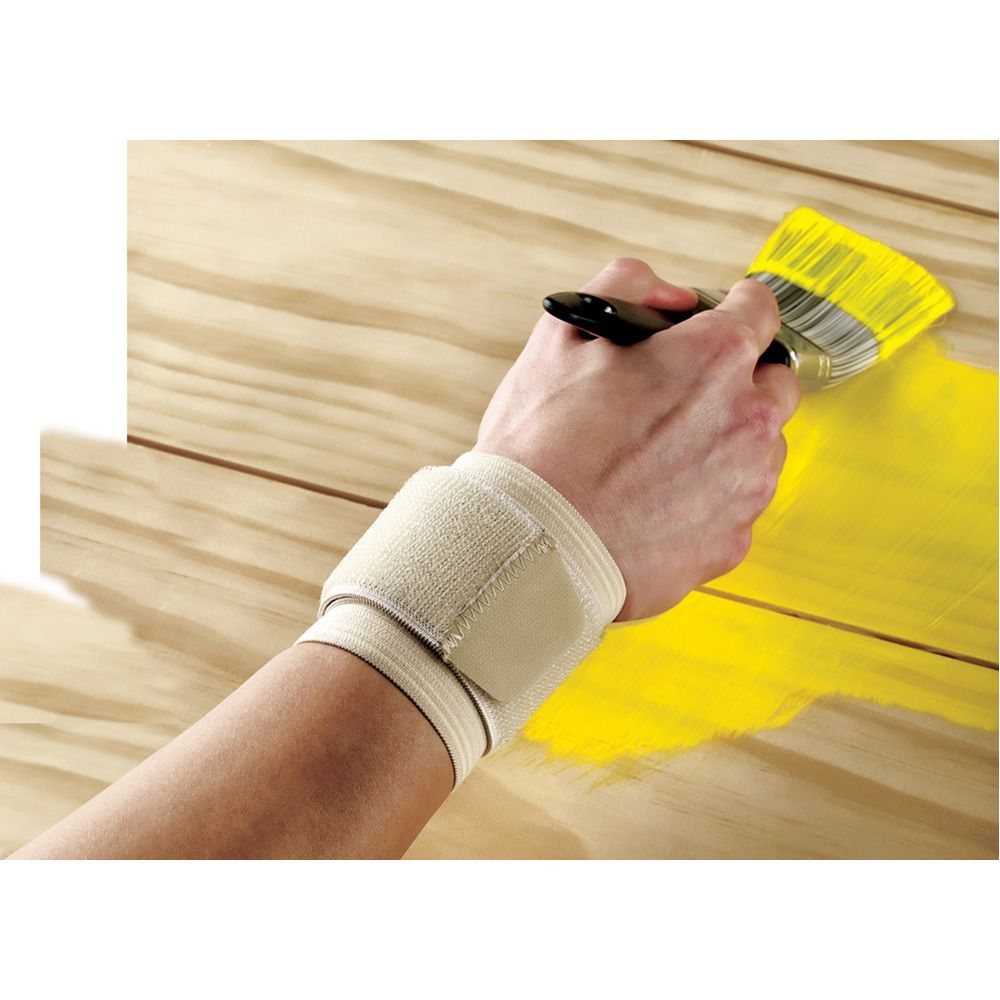 Hand mit FUTURO Handgelenk-Bandage, beige. Hand hält Pinsel. Bandage am Handgelenk.