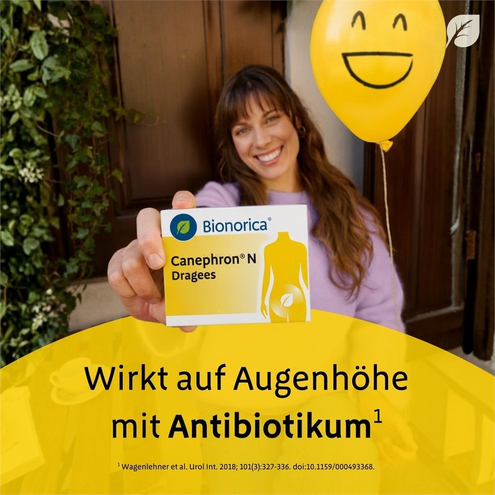 Frau hält Canephron® N Dragees Packung hoch. Wirkt auf Augenhöhe mit Antibiotikum.
