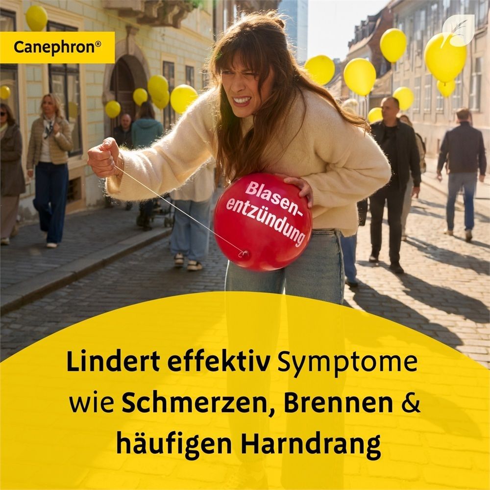 Frau zieht einen roten Ballon mit der Aufschrift 'Blasenentzündung' durch eine Straße. Text: 'Lindert effektiv Symptome wie Schmerzen, Brennen & häufigen Harndrang.'