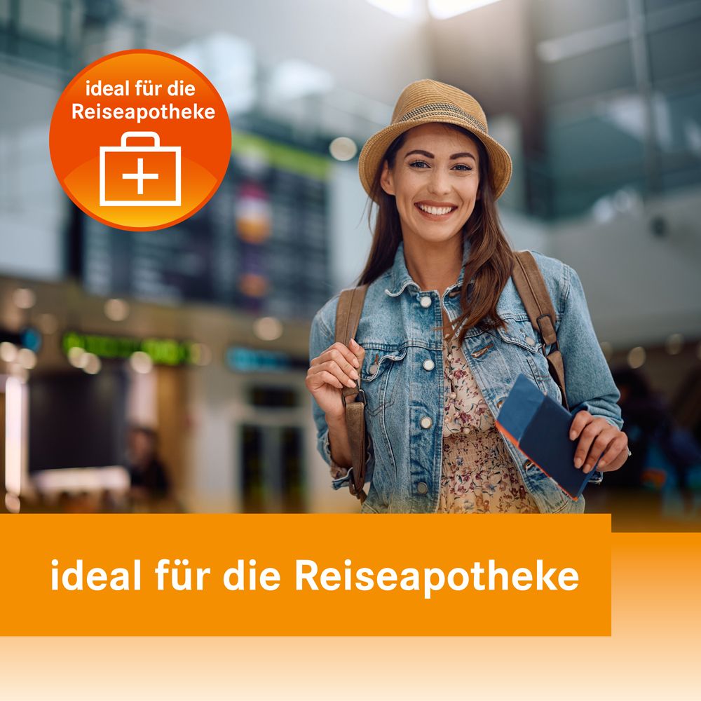 Frau am Flughafen. Text: ideal für die Reiseapotheke. Produktverpackung Loperamid akut Heumann.