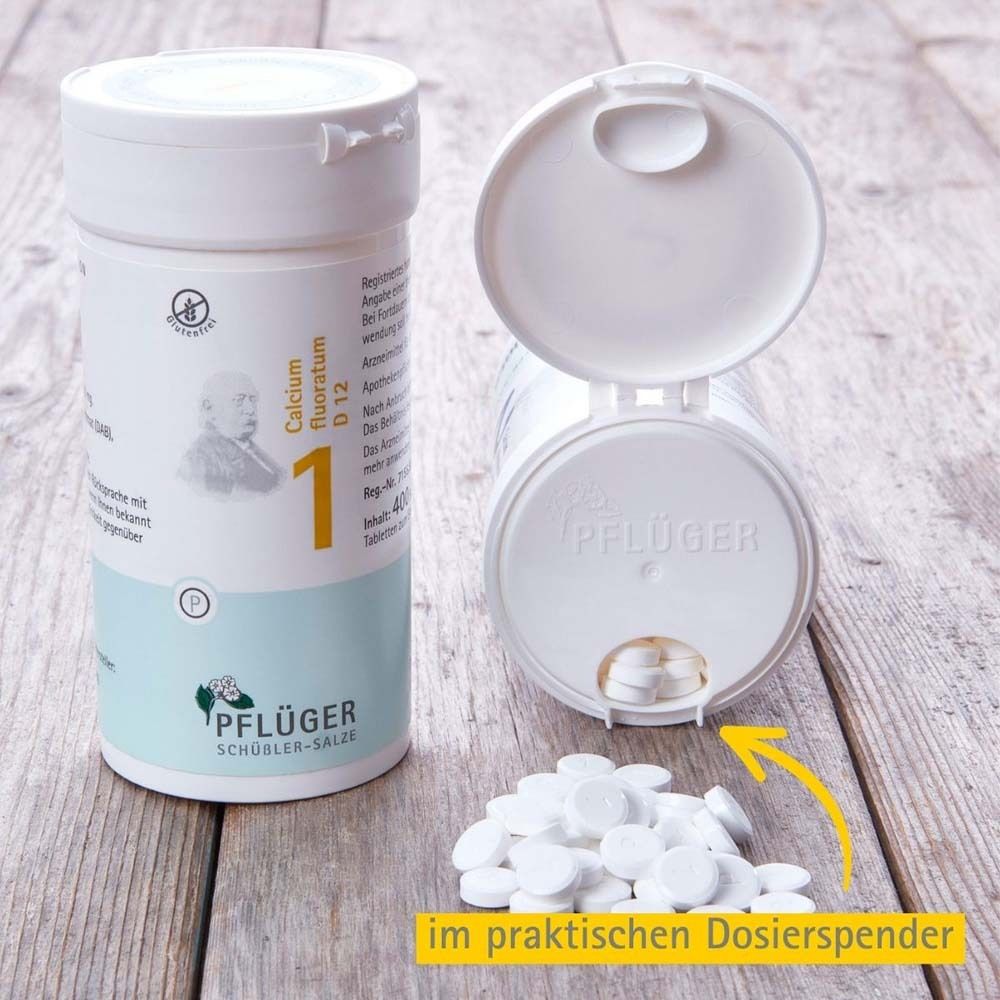 Tabletten-Behältnis geöffnet. Tabletten liegen daneben. Text: Calcium fluoratum D12, Pflüger.