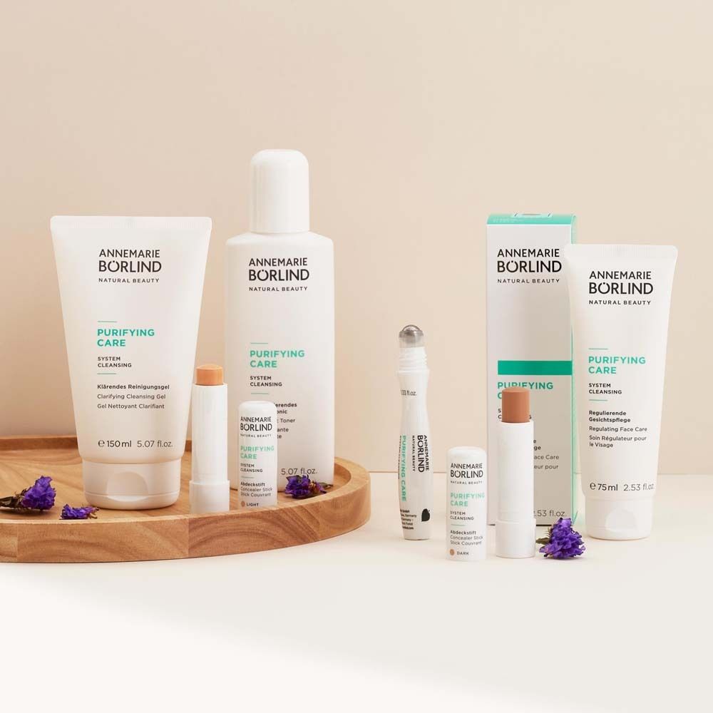 Verschiedene Kosmetikprodukte auf Holztablett. Produkte von ANNEMARIE BÖRLIND, PURIFYING CARE. Lavendelzweige.
