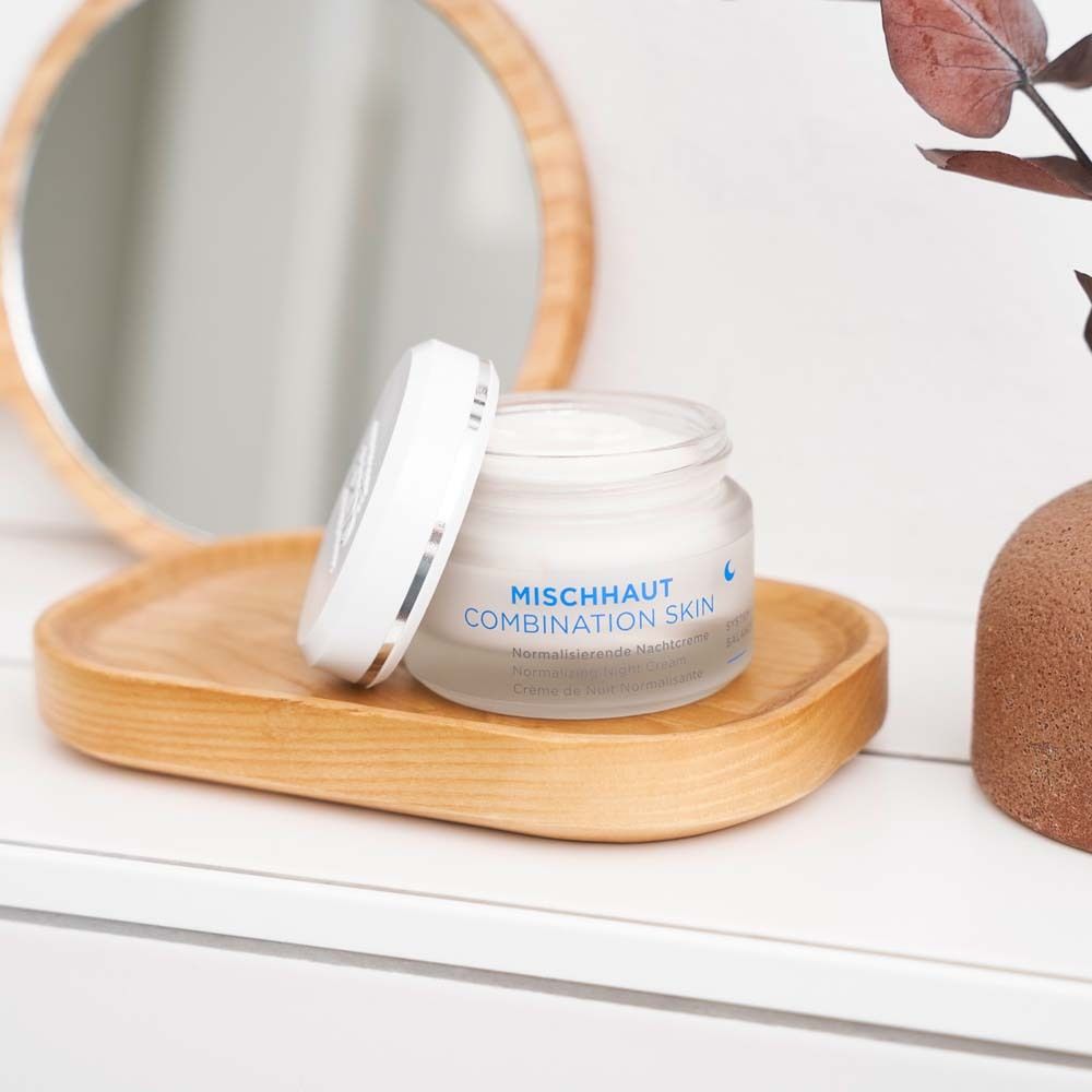 Creme-Tiegel mit geöffnetem Deckel auf Holztablett. Aufschrift: MISCHHAUT COMBINATION SKIN.