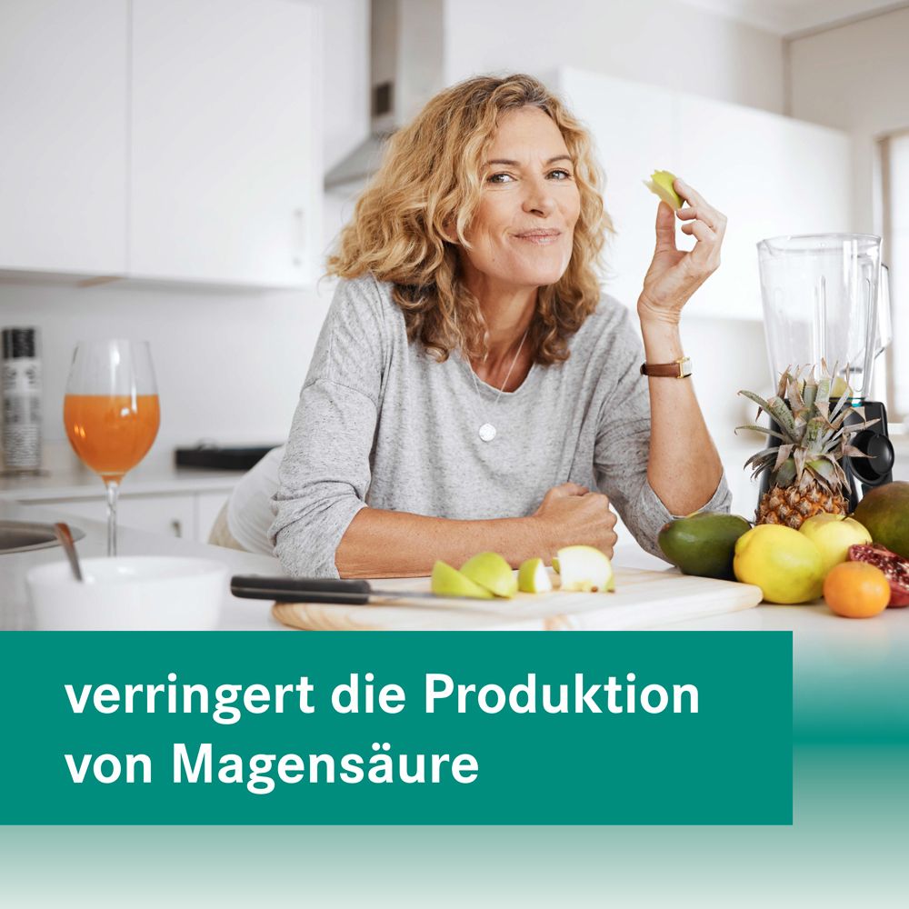 Frau in Küche mit Obst. Text: verringert die Produktion von Magensäure.