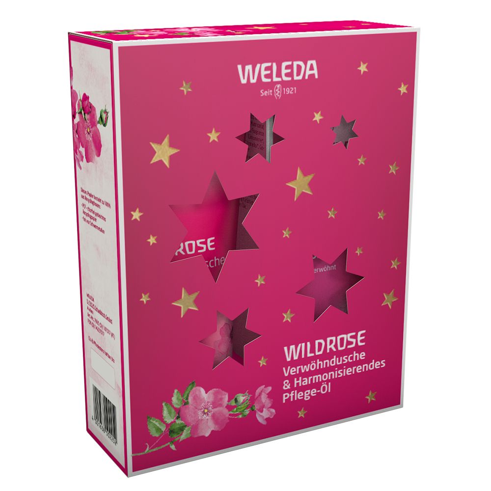 Rosa Geschenkbox mit Sternaussparungen. Aufschrift: WELEDA, WILDROSE, Verwöhndusche & Harmonisierendes Pflege-Öl. Sterne und Rosenblüten.