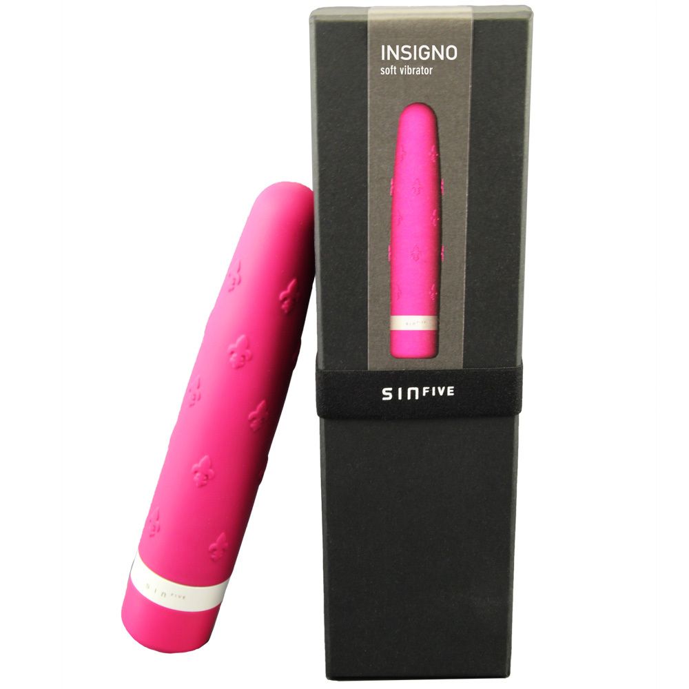Pinkfarbener Vibrator mit floralem Muster und weißem Ring. Neben schwarzer Verpackung mit Produktnamen und Markennamen.