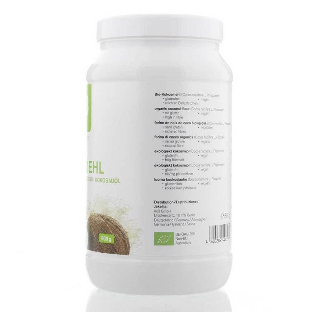 Weißes Produktglas mit grünem Etikett. Aufschrift: Kokosmehl, Bio-Siegel. Enthält Informationen in mehreren Sprachen. 500g.