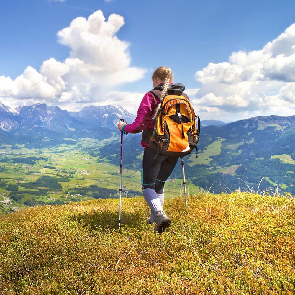 Personne avec sac à dos randonnée en montagne. Paysage avec ciel et montagnes.
