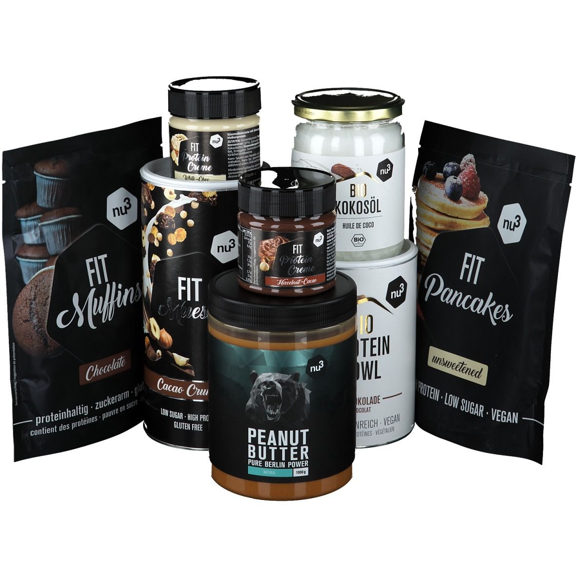 Verschiedene nu3 Produkte: Muffins, Pancakes, Protein Bowl, Erdnussbutter, Kokosöl und Protein Creme. Verpackungen in Schwarz und Weiß.