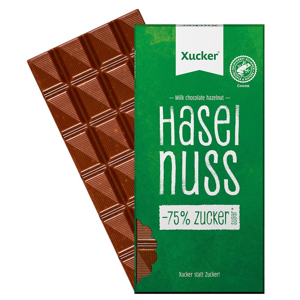 Schokoladentafel neben grüner Verpackung. Tafel mit quadratischen Stücken. Verpackung mit "Haselnuss"-Schriftzug.