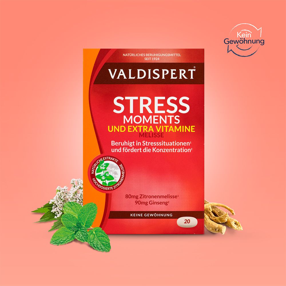 VALDISPERT® Stress Moments & Extravitamine Packung. Produkt mit Kräutern und Wurzeln auf rosa Hintergrund.