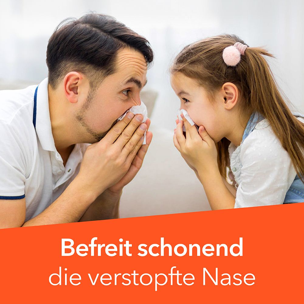 Vater und Kind mit Taschentüchern, die sich ansehen. Text: Befreit schonend die verstopfte Nase.