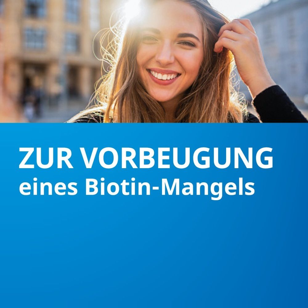 Junge Frau lächelt, Text: Zur Vorbeugung eines Biotin-Mangels.