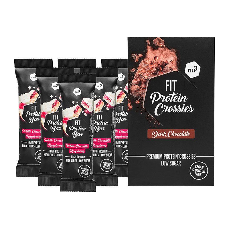 Sechs Proteinriegel und eine Schachtel Fit Protein Crossies. Riegel mit weißer Schokolade und Himbeere. Schachtel mit dunkler Schokolade.